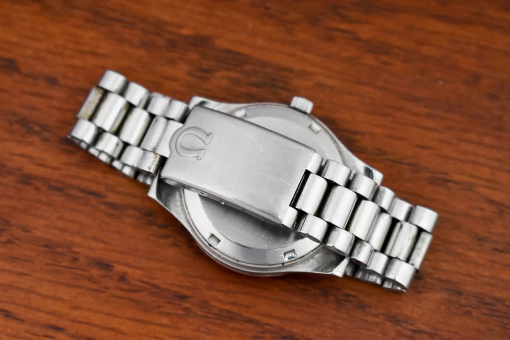 Omega Genève caseback and bracelet resting on wood