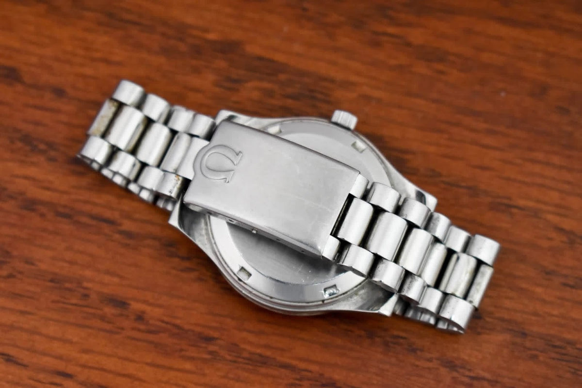 Omega Genève caseback and bracelet resting on wood