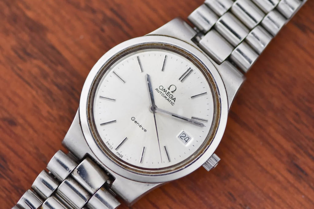 Omega Genève angled on wood, silver dial and date window at three