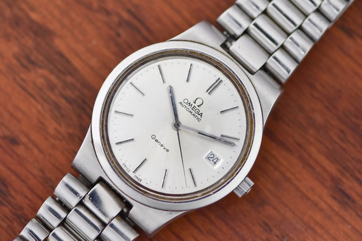 Omega Genève angled on wood, silver dial and date window at three