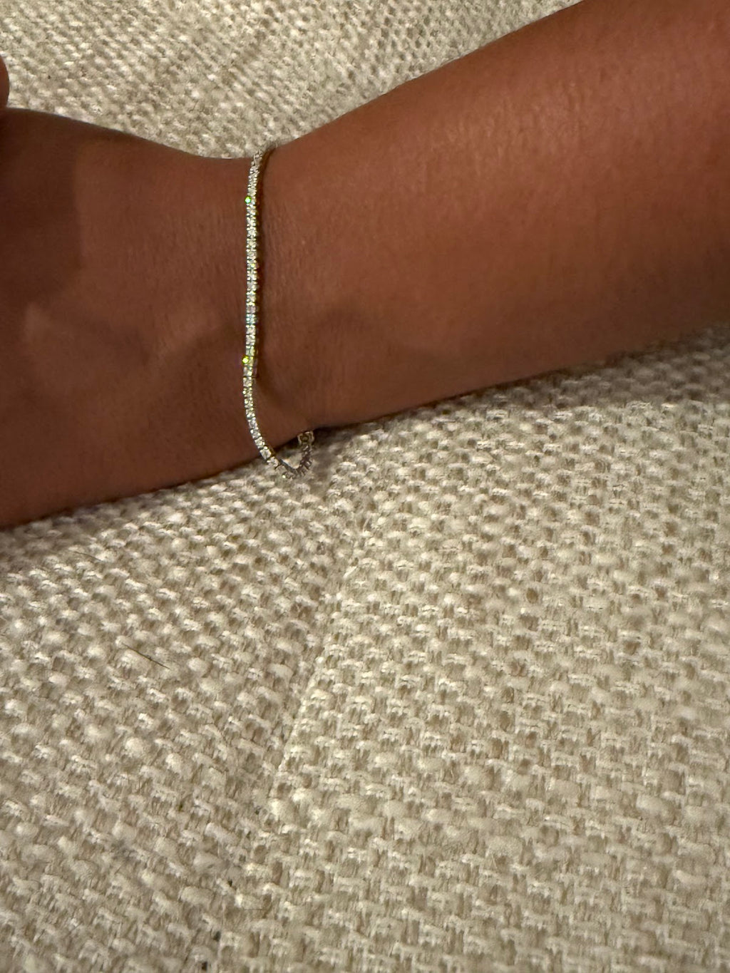 Lab diamond tennis bracelet draped, showing continuous line of round brilliants