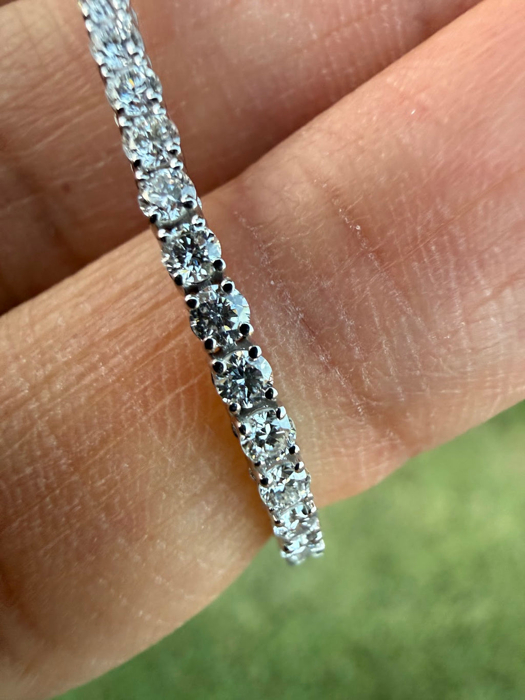 Close-up of round brilliant lab diamonds in four-prong settings on the tennis bracelet